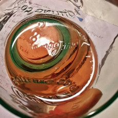 Detail shot of Rosé wine in a greenish water glass.